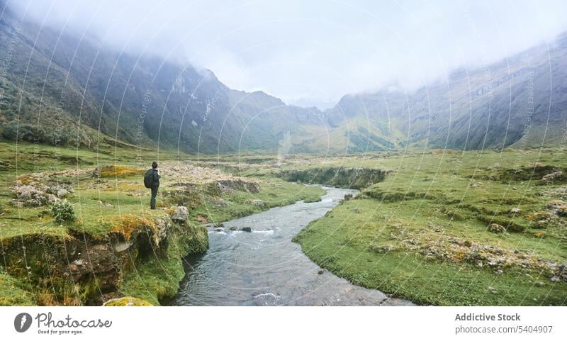 Reisende Frau, die auf einem Stein am Fluss steht Berge u. Gebirge bewundern Vulkan Tal Reisender Natur Hochland Tourist Rucksack spektakulär Altar Ecuador