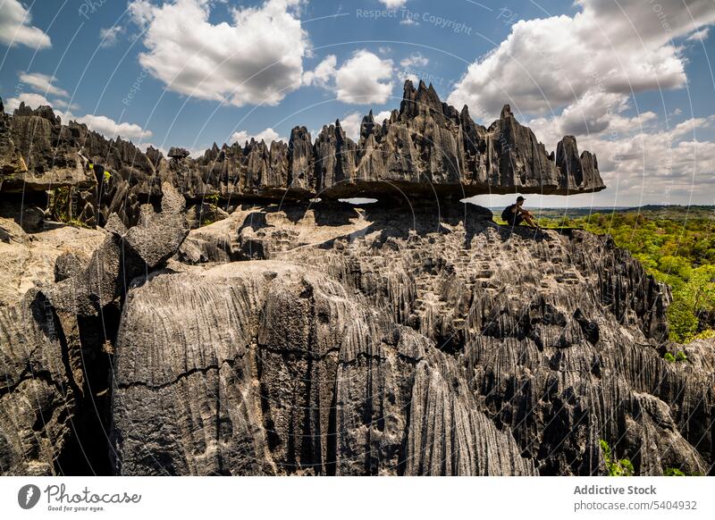 Unbekannter männlicher Reisender sitzt unter Felsformationen Mann Klippe Felsen Stein Landschaft Berge u. Gebirge Abenteuer Park Hintergrund bewundern Voute