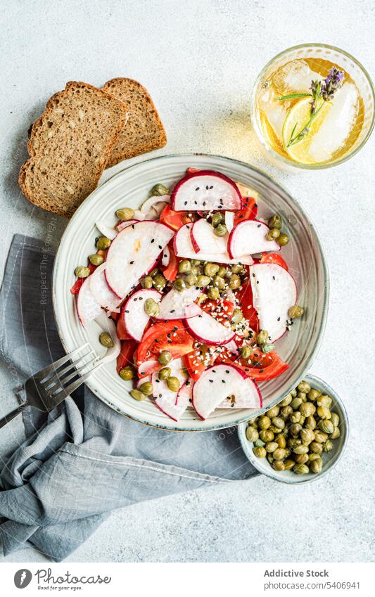 Gemüsesalat mit Bio-Tomaten und Kapern, Limonade und Brot Schalen & Schüsseln konserviert Kapriolen Kapparis Küche Abendessen Lebensmittel frisch Glas grün