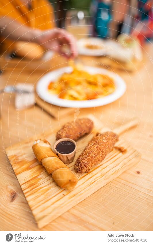 Leckere Brötchen und Kroketten auf dem Schneidebrett lecker rollen dienen Saucen Lebensmittel Tisch Restaurant trinken appetitlich kulinarisch frisch Mahlzeit