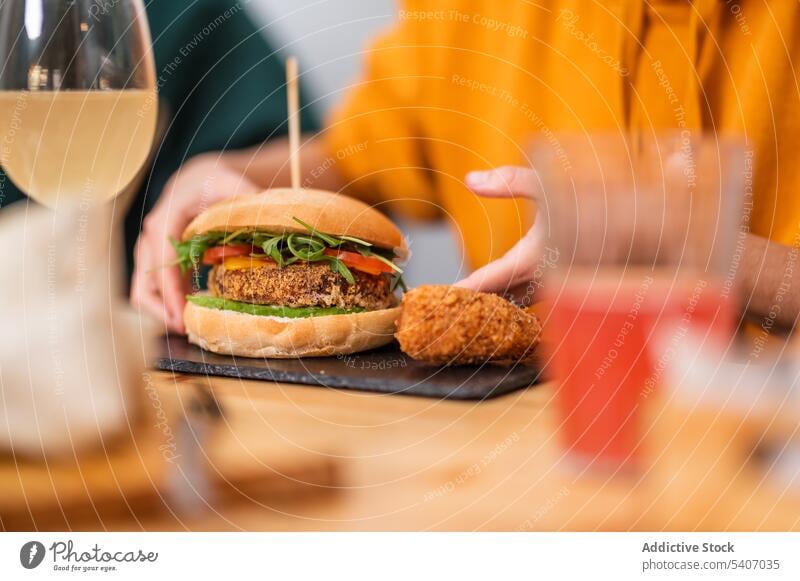 Kropfträger mit Hamburger im Restaurant essen Burger lecker geschmackvoll Snack Kantine Portion Lebensmittel Café hungrig Speise Teller Tisch Mahlzeit