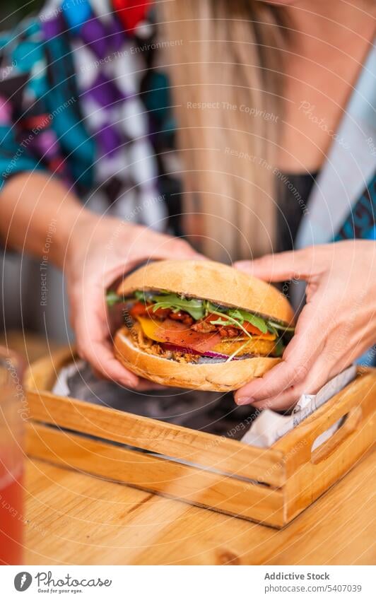 Anonyme Frau isst Burger im Restaurant essen Getränk lecker Lebensmittel geschmackvoll Tisch Pause Kantine sitzen Gemüse Mittagessen lässig Mahlzeit Fastfood