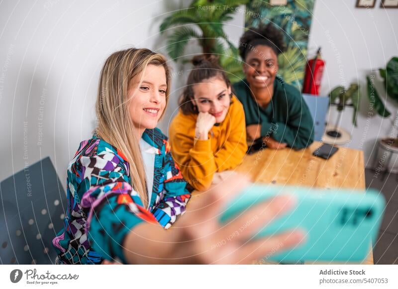 Fröhliche, diverse Freunde machen ein Selfie mit ihrem Smartphone Menschengruppe Zusammensein heiter fotografieren Glück Freundschaft Lächeln Telefon