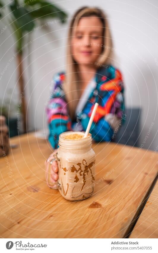 Frau mit einer Flasche heißen Kaffees auf dem Tisch Café Restaurant lecker trinken geschmackvoll jung Getränk lässig sitzen ruhen Lebensmittel frisch genießen