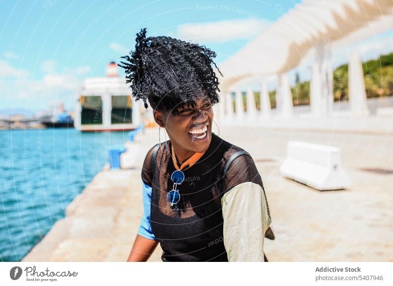 Charmante schwarze Frau auf dem Deich in der Stadt Strandpromenade Hafengebiet genießen sich[Akk] entspannen sonnig Afro-Look Frisur charmant Lächeln ethnisch