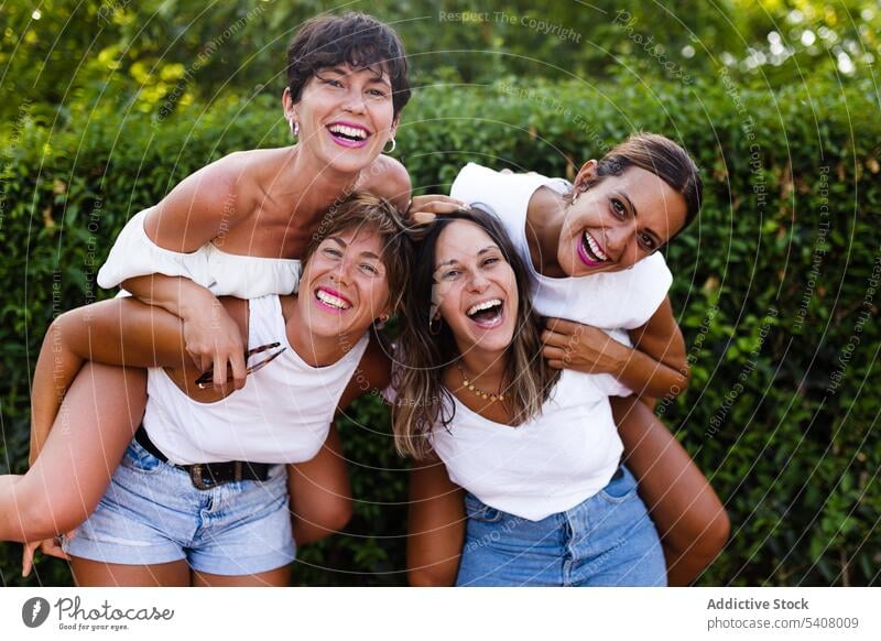 Gesellschaft von fröhlichen Frauen, die Spaß in der Stadt haben Huckepack Spaß haben Freundschaft Lachen Humor Bonden Großstadt Sommer Wochenende Zusammensein