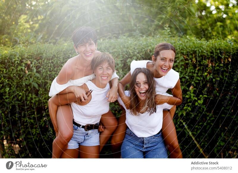 Gesellschaft von fröhlichen Frauen, die Spaß in der Stadt haben Huckepack Spaß haben Freundschaft Lachen Humor Bonden Großstadt Sommer Wochenende Zusammensein