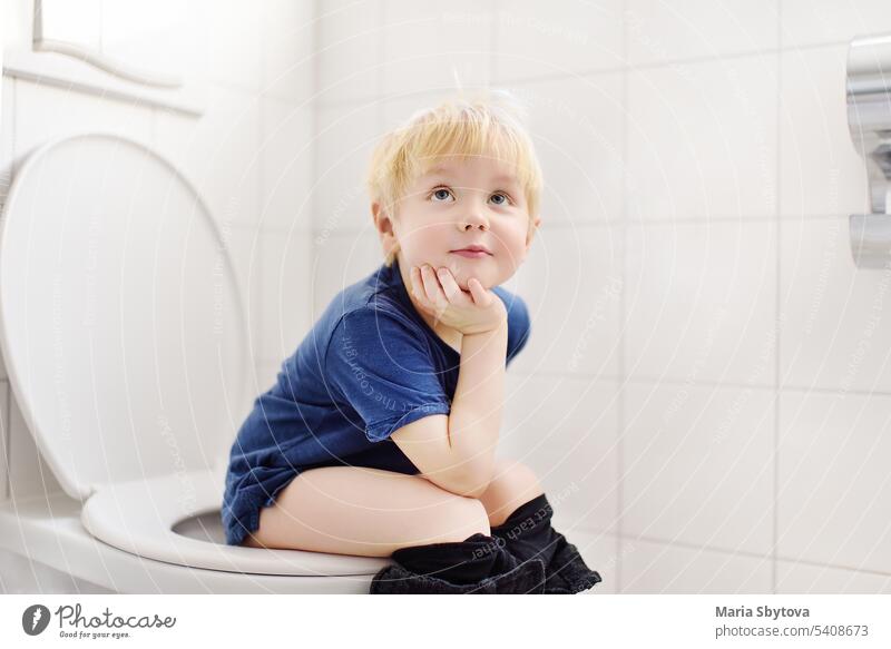 Niedlicher kleiner Junge auf der Toilette. Kleinkind Kind ist die Ausbildung verwenden Toilette. Behandlung von Verstopfung von kleinen Kindern. Lehre Kinder der Hygiene