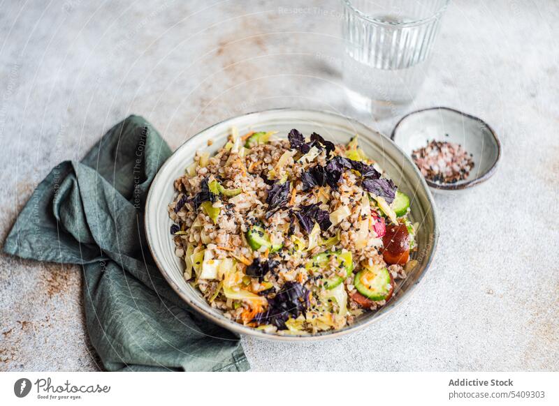 Leckeres Buchweizengericht in einer Schüssel auf dem Tisch Gemüse Zwiebel Salatgurke Tomate Basilikum Schalen & Schüsseln Veggie Salatbeilage Vegetarier Kraut