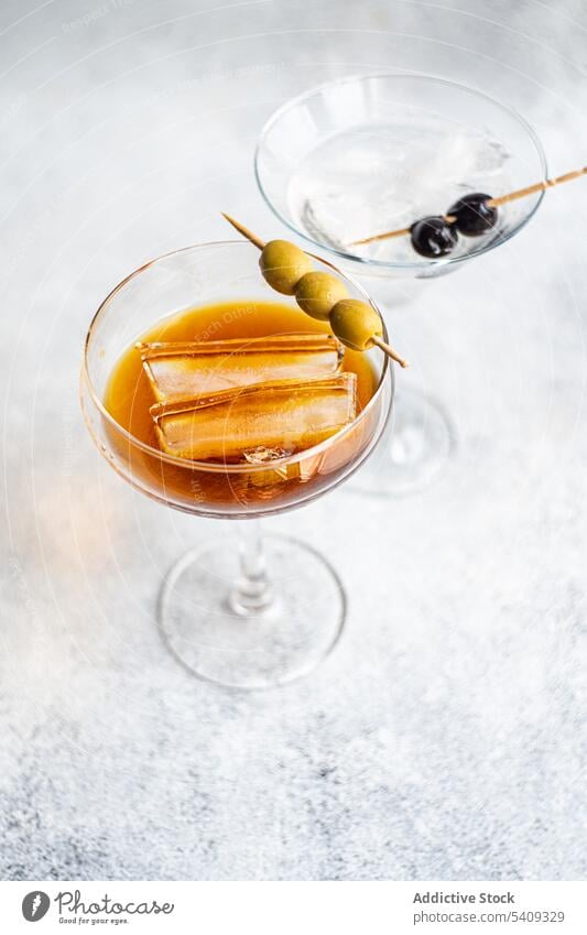 Cocktailgläser mit alkoholischem Whiskey und Olivenstäbchen Eis Glas trinken Alkohol Glaswaren Scheibe kleben oliv Portion Aperitif dienen Getränk lecker