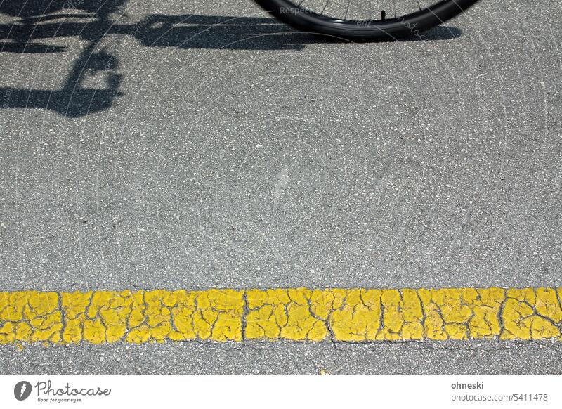 Asphaltierte Straße mit Fahrrad am oberen Bildrand Verkehrswege Straßenverkehr Mobilität Wege & Pfade Bewegung Fahrradreifen Fahrradfahren Fahrradtour