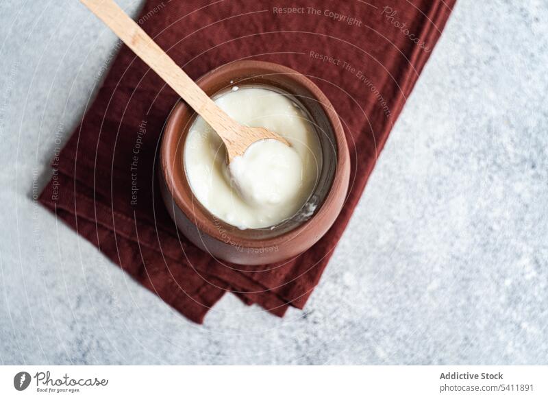 Traditionelle Portion georgischer saurer Joghurt, bekannt als Matsoni, im Tontopf sauer traditionell Dessert Kultur matsoni Topf Löffel hölzern rustikal