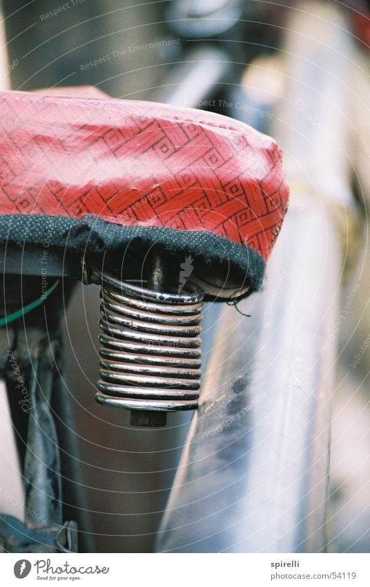 roter Bezug Fahrrad Verkehr bequem springen Verkehrsmittel unbequem Spannung Überzug Kraft Oldtimer Nahaufnahme Indien Makroaufnahme Spirale Fahrradsattel Feder