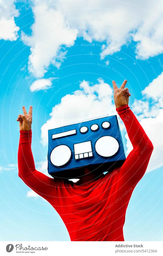 Mann mit Boombox zeigt Siegeszeichen gegen den Himmel zeigen v-Zeichen Frieden gestikulieren Deckblatt zuhören Musik zwei Finger männlich Blauer Himmel lässig