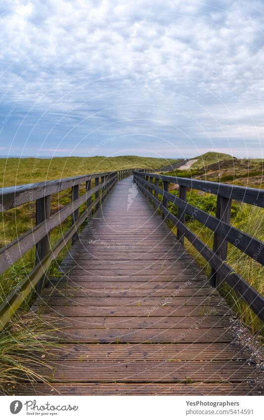 Nasser Holzfußweg auf der Insel Sylt, Deutschland. Abenteuer Herbst schön Brücke Klima Wolken wolkig Küste Farbe Dunes Europa Fußweg Gras grün Hügel Wahrzeichen