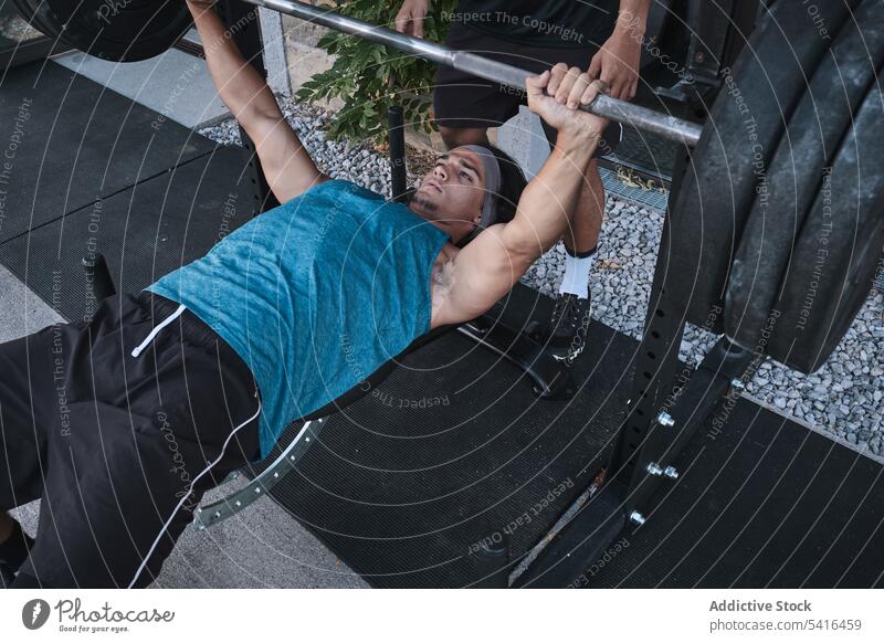 Ethnischer Mann hebt Langhantel mit Trainer Athlet Heben Curl-Hantel Trainerin Fitnessstudio männlich hispanisch Sport Übung Training Gesundheit Gewicht