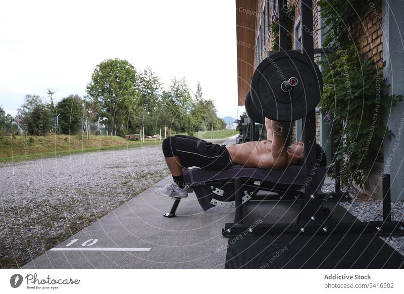 Schwarzer hebt Langhantel auf der Straße Mann Curl-Hantel Heben Fitnessstudio Großstadt ohne Hemd Sport anstrengen männlich Athlet schwarz ethnisch Afrikanisch