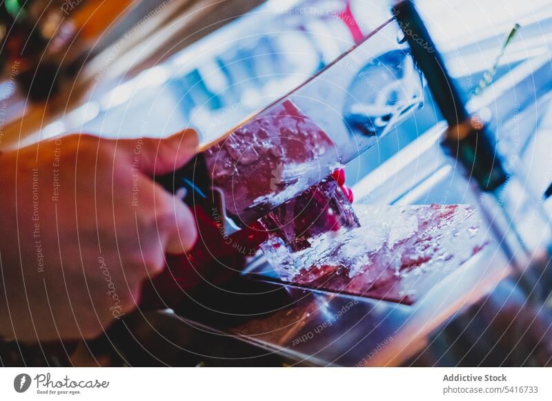 Barkeeper schneidet Eiswürfel mit Eispickelmesser Schneiden Nachtclub Messer vorbereitend Barmann Cocktail Uniform Glas trinken Getränk alkoholisch liquide