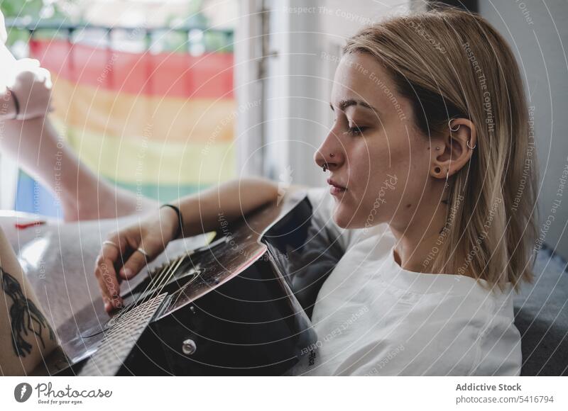 Gitarre spielende Frau auf dem Bett Spielen heimwärts Sitzen heiter jung Schlafzimmer Musik Lifestyle Freizeit Hobby Glück Freude Komfort gemütlich tätowiert