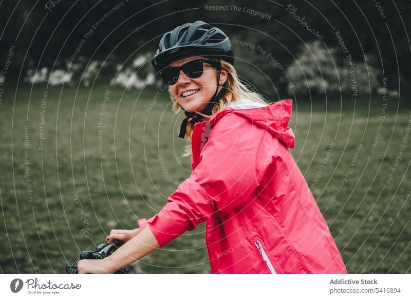 Lächelnde Frau auf dem Fahrrad Reiten in die Kamera schauen Straße jung Person heiter aktiv sportlich Radfahrer genießend Lifestyle reisen Verkehr Abenteuer