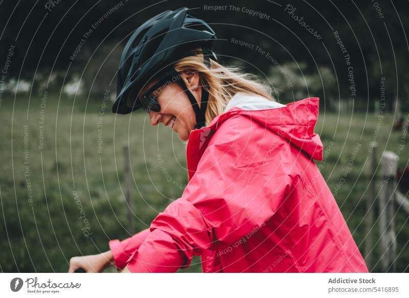 Lächelnde Frau auf dem Fahrrad Reiten Straße jung Person heiter aktiv sportlich Radfahrer genießend Lifestyle reisen Verkehr Abenteuer Schutzhelm Sonnenbrille