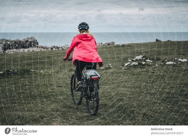 Radfahrerin fährt auf einer Bergstraße Frau Fahrrad Reiten Straße Schutzhelm felsig Rückansicht Berge u. Gebirge Landschaft Erwachsener Person aktiv sportlich