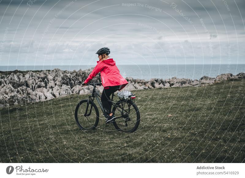 Radfahrerin fährt auf einer Bergstraße Frau Fahrrad Reiten Straße Schutzhelm felsig Berge u. Gebirge Landschaft Erwachsener Person aktiv sportlich allein