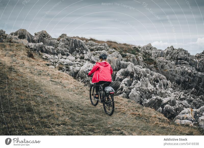 Radfahrerin fährt auf einer Bergstraße Frau Fahrrad Reiten Straße Schutzhelm felsig Berge u. Gebirge Landschaft Erwachsener Person aktiv sportlich allein