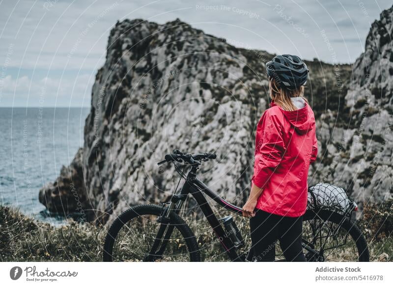 Anonyme Radfahrerin auf Felsen Frau Fahrrad Klippe Schutzhelm MEER Landschaft unkenntlich extrem jung Person heiter aktiv laufen Lifestyle Mitfahrgelegenheit