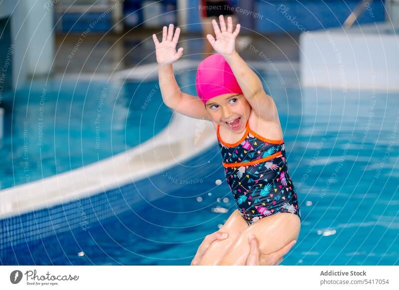 Mutter spielt mit Tochter im Schwimmbad Spaß Wasser Schwimmsport Pool Heben ausgestreckte Arme ethnisch Spielen Zusammensein Familie Eltern Frau Mädchen Kind