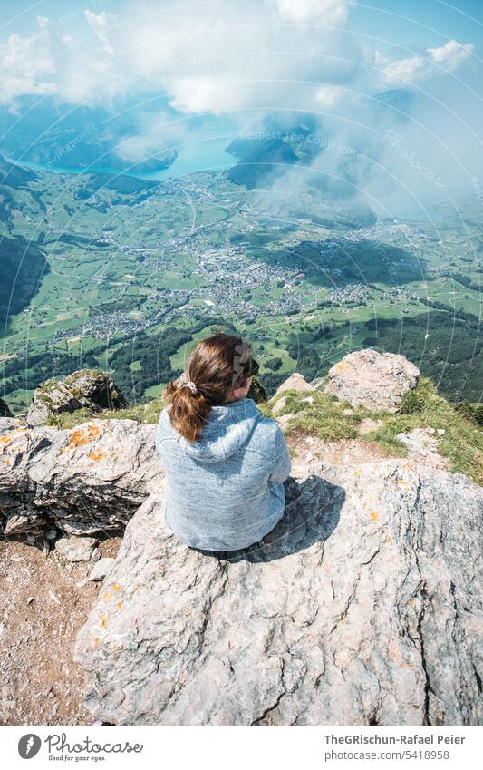 Frau sitzt auf Stein und schaut in die Ferne Farbfoto grosser mythen Berge u. Gebirge wandern Schweiz Tourismus Alpen Landschaft Außenaufnahme Wanderstöcke