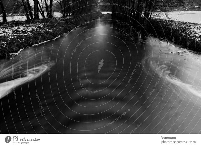 Langzeitbelichtung eines Flusses im Winter in Deutschland, schwarz-weiß Flüsse Wasser Wasserreflexionen Wald Wälder Ast Niederlassungen grüne Lunge Blatt