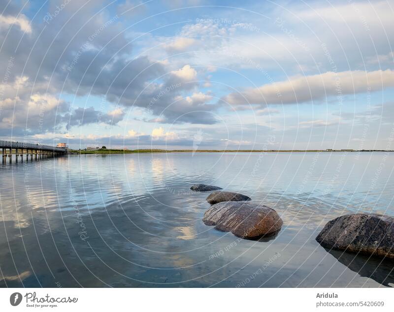 Ostseelagune im Abendlicht mit Findlingen und Fußgängerbrücke bei Kopenhagen Himmel Wilken Wasser klar frisch Steine Abendstimmung Lichtstimmung Landschaft