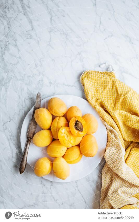 Teller mit frischen Aprikosen auf weißem Marmortisch Frucht reif Tisch gelb orange natürlich Lebensmittel lecker geschmackvoll Gesundheit organisch Bestandteil