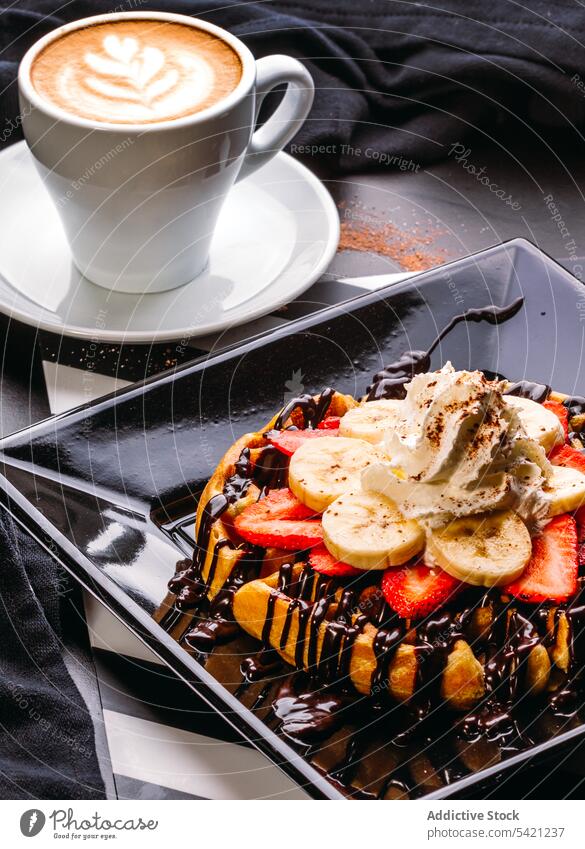 Waffel mit Beeren und Schlagsahne zum Frühstück süß Kaffee Cappuccino Erdbeeren Banane gepeitscht Sahne Schokolade Saucen Dessert Gebäck Bäckerei Belag