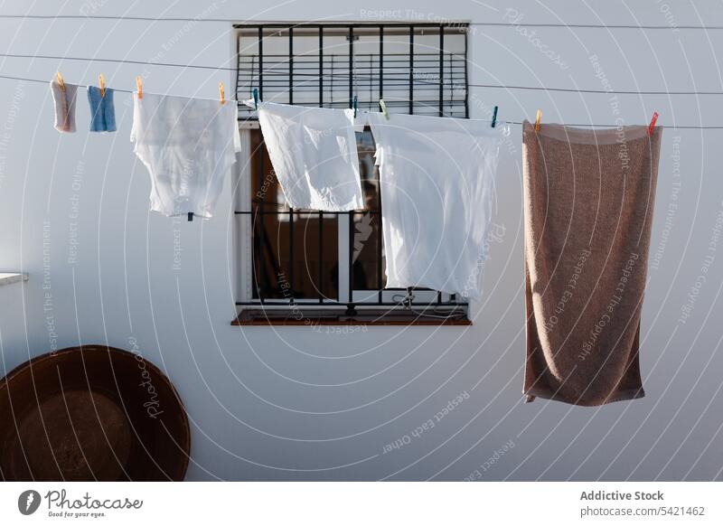 An einem Seil hängende Leinen im Hof Wäscherei Wäscheleine Land ländlich Waschen Stoff Haus Haushalt Hausarbeit Sauberkeit trocknen heimisch Fenster Arbeit