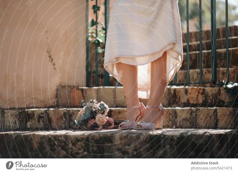 Unerkennbare Braut in eleganten Schuhen mit Blumenstrauß Stil Frau Hochzeit romantisch Anlass Damenschuhe rosa filigran Piep-Zehe hochzeitlich Bein Kleid