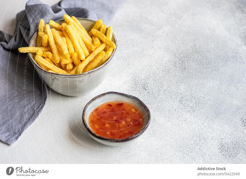 Pommes frites und süß-saure Soße Französisch Fries sauer Saucen Schalen & Schüsseln Keramik weiß Oberfläche Serviette blau Stoff Unschärfe hoher Winkel von oben