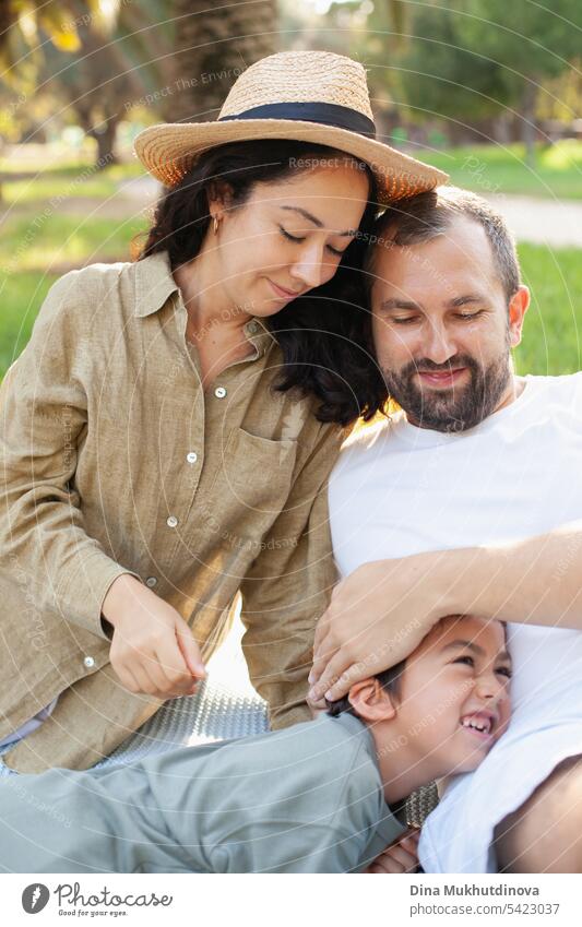 glückliche Familie lächelnd mit einem Sohn im Park im Freien im Sommer Mama Papa Vater Mutter Elternschaft Vaterschaft Mutterschaft Liebe Zusammensein Kind