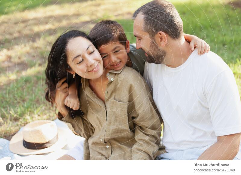 glückliche Familie lächelnd mit einem Sohn im Park im Freien im Sommer Mama Papa Vater Mutter Elternschaft Vaterschaft Mutterschaft Liebe Zusammensein Kind