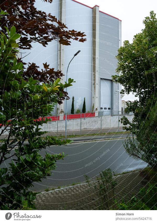 Lagerhalle mit Eingangstor und einrahmenden Bäumen Infrastruktur Gewerbegebiet Gebäude Industrie Fabrik Strukturen & Formen Arbeit & Erwerbstätigkeit Halle