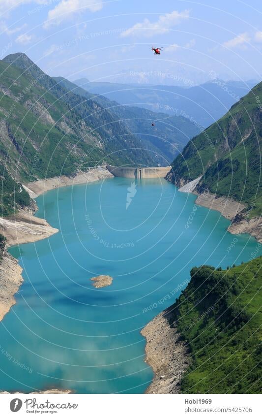 Hubschrauber fliegt über die Stauseen bei Kaprun Helikopter Österreich fliegen Rotor See Wasser Staumauer aufstauen Energie Arbeit Transport transportieren