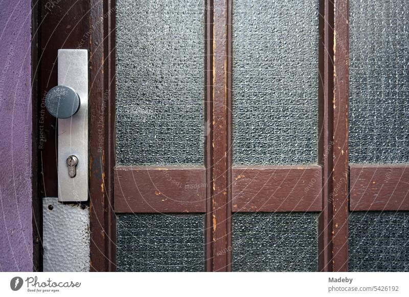 Alte Haustür aus braunem Holz mit Riffelglas und Türgriff im Stil der Nachkriegszeit in der Hanauer Landstraße im Ostend von Frankfurt am Main in Hessen altbau