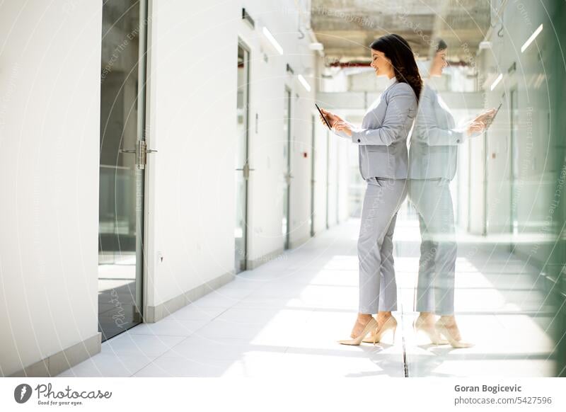 Junge Geschäftsfrau, die im Büroflur ein Mobiltelefon benutzt Frau Kaukasier professionell Business Flur Menschen Telefon Person selbstbewusst sprechend