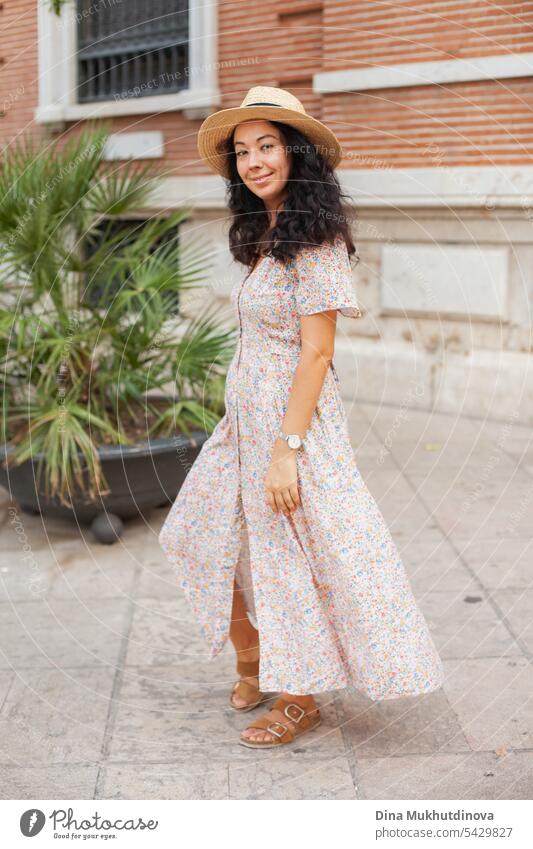 Schöne Touristin mit Strohhut in Valencia, Spanien. Brunette Frau Spaß Länge Porträt in Sommerkleid zu Fuß die Straße. schön traumhaft Tourismus Sightseeing