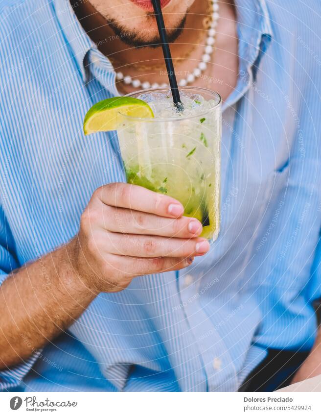 Ein junger Mensch genießt einen Mojito mit Rum, Limette und Minze Erwachsener Alkohol alkoholisch Bar Getränk Kaukasier zu feiern Feier Champagne heiter