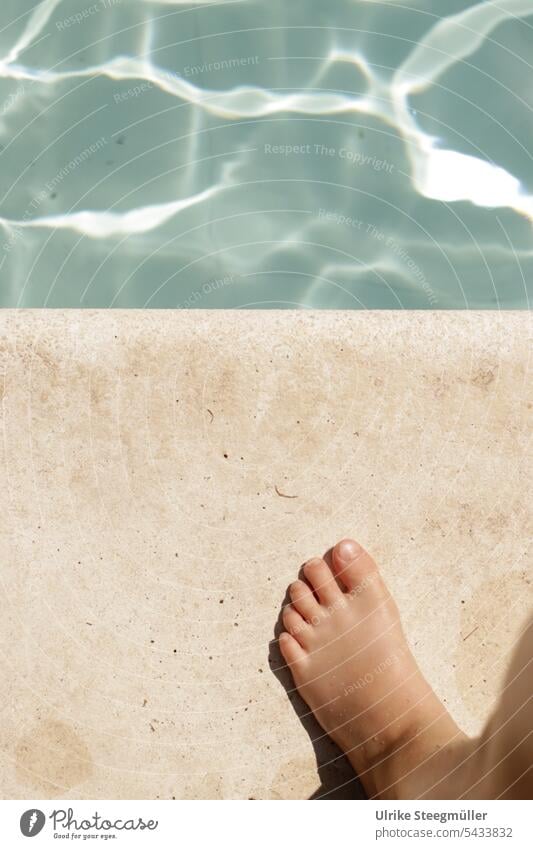 Ein Kind steht am Beckenrand blau Wasser Kinder Urlaub mit Kindern Ferien Schwimmen lernen Sprung vor dem Sprung ins kühle Nass Mut sich trauen Risiko Hitze