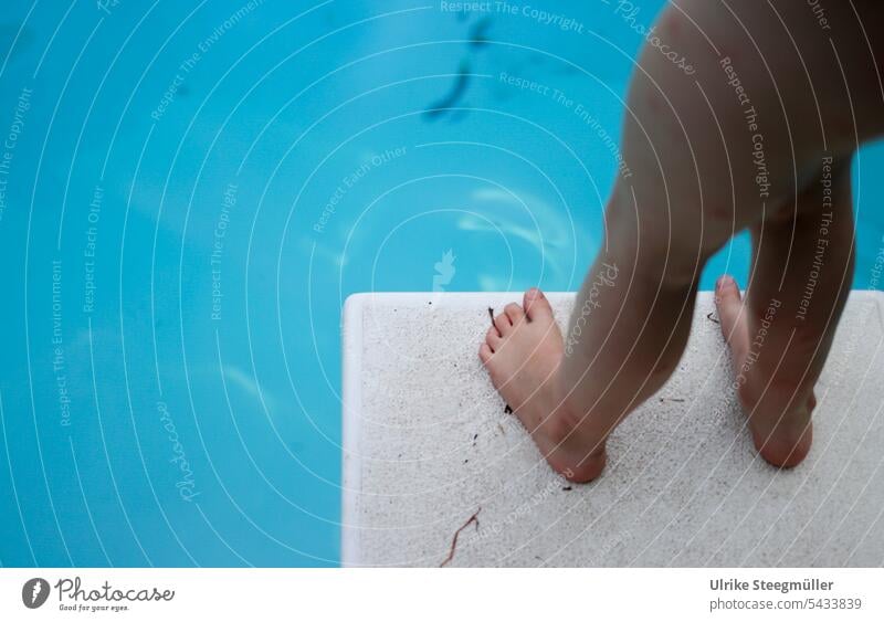 Ein Kind steht auf dem Sprungbrett kurz vor dem Sprung blau Pool Schwimmbecken sprung schwimmen lernen tauchen Urlaub mit Kindern Sonne Hitze Abkühlen