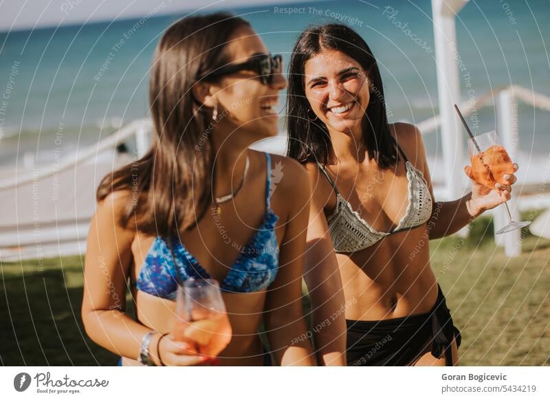 Lächelnde junge Frauen im Bikini genießen den Urlaub am Strand Erwachsener Bekleidung Tag trinken Emotion Mode Fröhlichkeit Feiertag Italien Freizeitaktivitäten