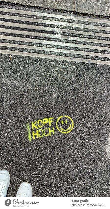 Kopf Hoch Smiley auf dem Asphalt aus der Vogelperspektive Kopf hoch Smiley-Symbol Smiley-Gesicht kopf hoch smiley Straßenkunst gesprayt Graffiti emoji symbol